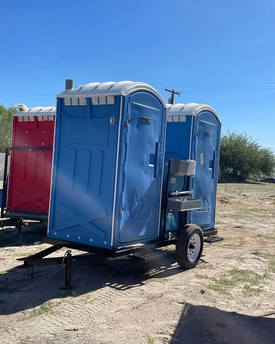 Two porta potties mounted on a small trailer
