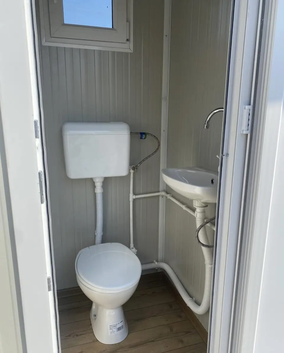 Porcelain toilet and vanity sink inside a VIP cabin.