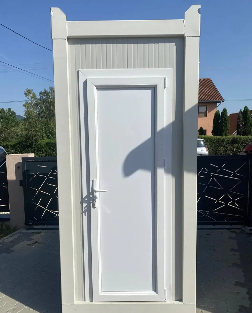 White single-stall restroom cabin with a paneled door